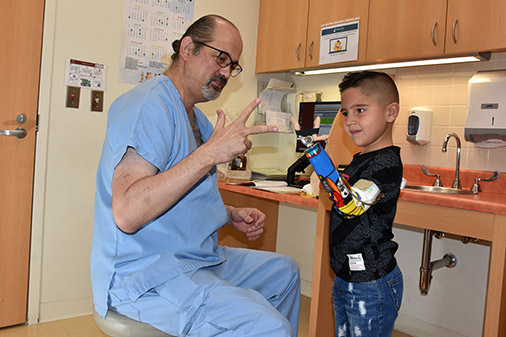 Doctor Hernández mostrando cómo utilizar la pinza de la prótesis a un paciente