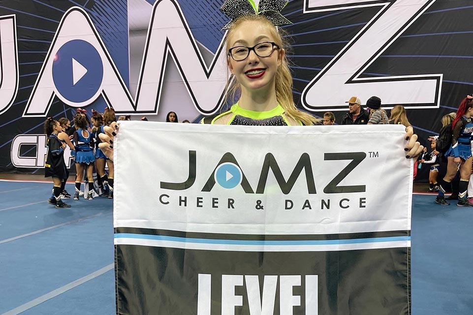 Payton holding banner during cheer competition