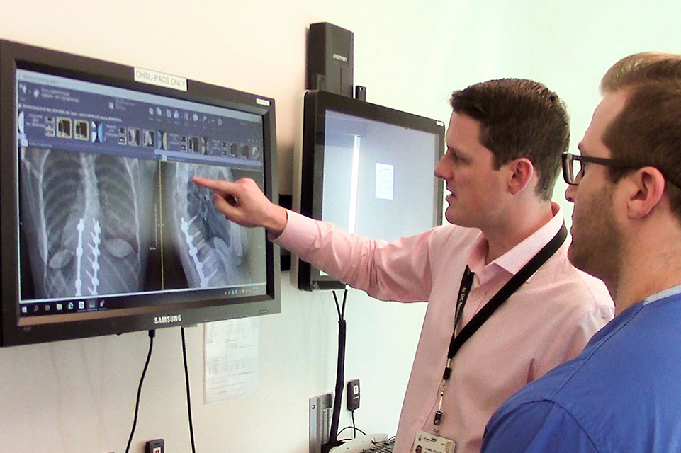 Two healthcare providers reviewing x-rays