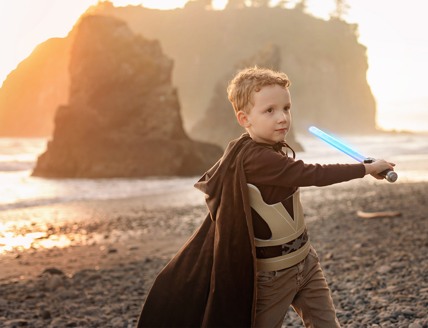Liam disfrazado de Obi-wan Kenobi, blandiendo un sable de luz