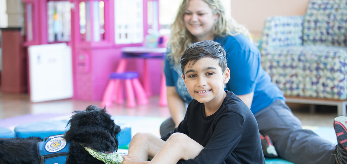 patient with therapy dog and therapist
