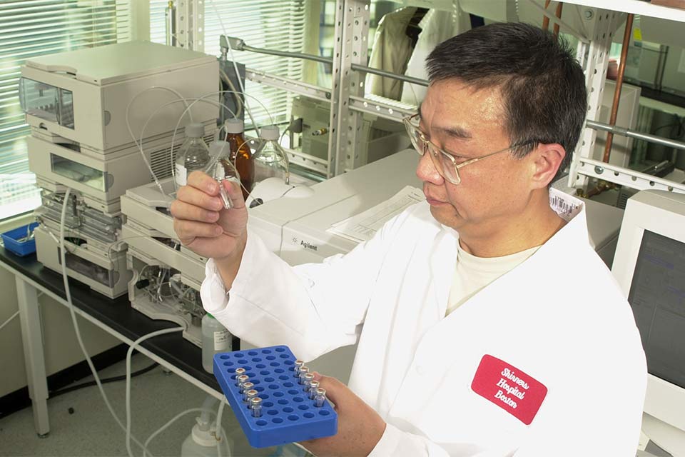 Research staff member in lab holding test tube