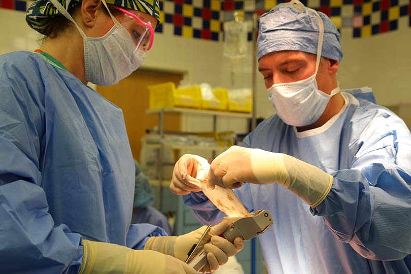 Two medical personnel creating a skin graft