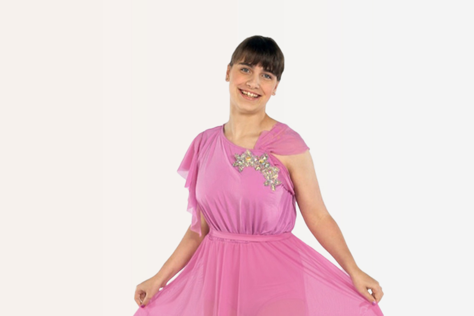 Une fille en costume de danse fait la révérence en souriant