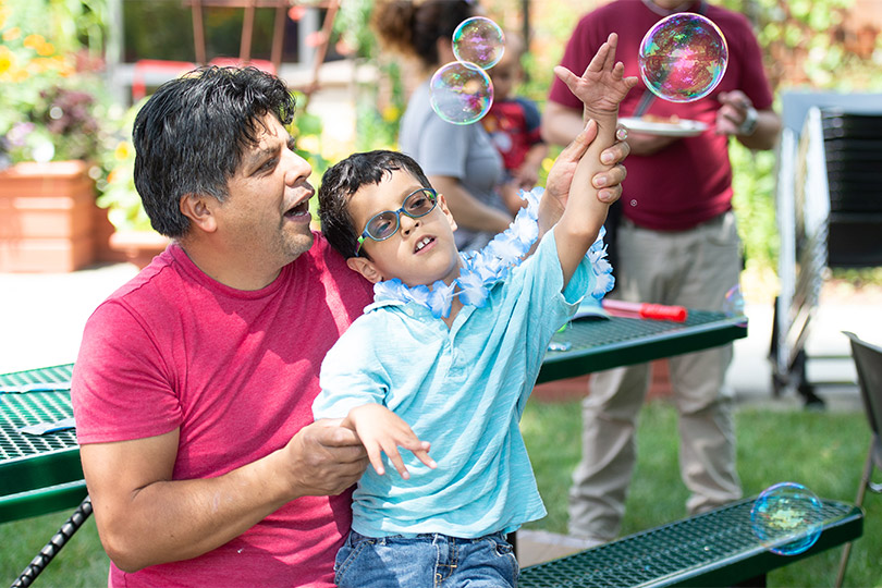 un patient et son père jouant avec des bulles