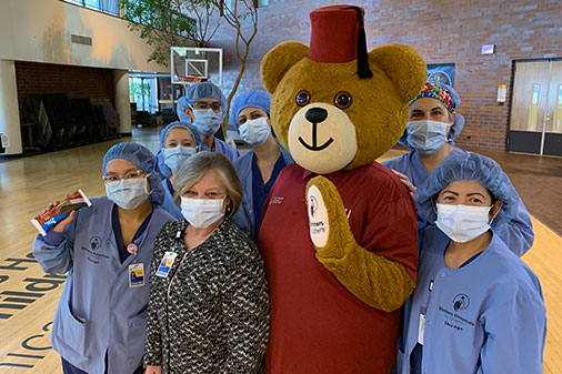 staff members with Fezzy the bear