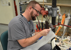 miembro masculino del personal trabajando en un dispositivo prostético