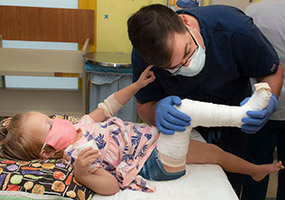 médico examina la pierna de un paciente