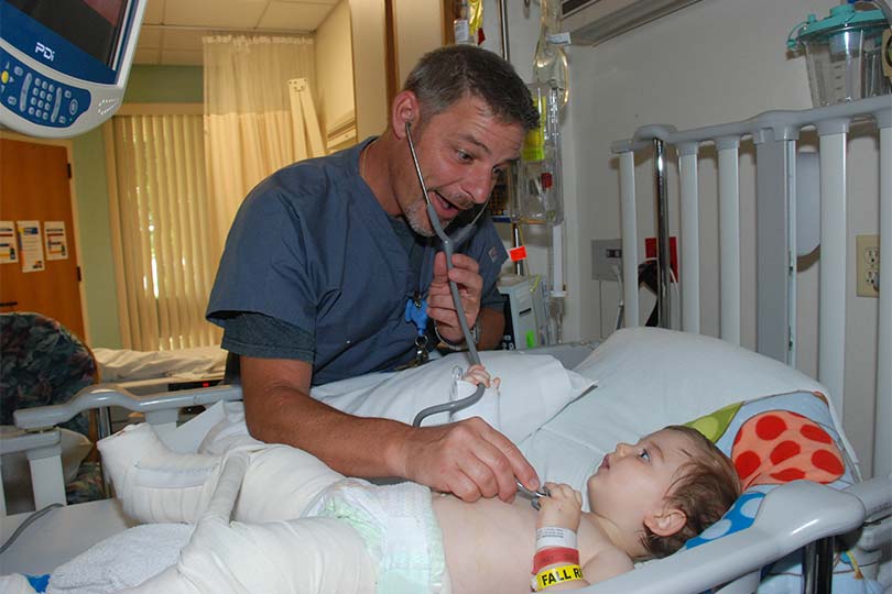 Doctor escuchando el corazón de un niño con un estetoscopio.