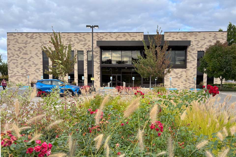 a brick building in front of a flower lawn