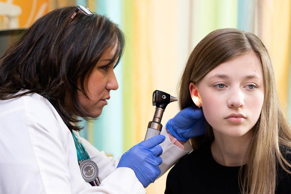 médico examina el oído del paciente