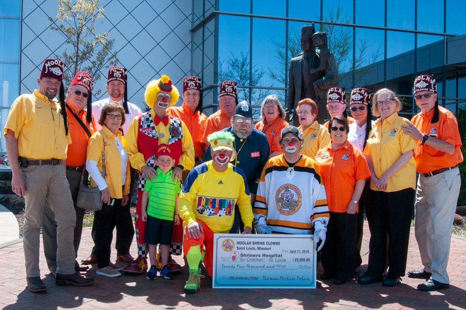 check donation with Shriners, patients and clowns
