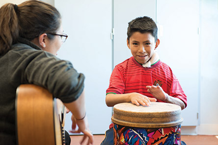 male patient in music therapy playing drum