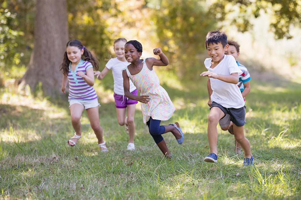 Grupo de niños corriendo por el bosque