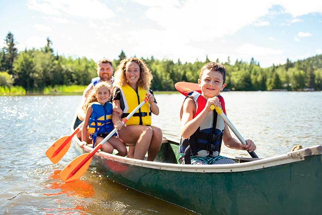 family wearing life jackets in canoe