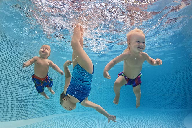 three children swimming underwater