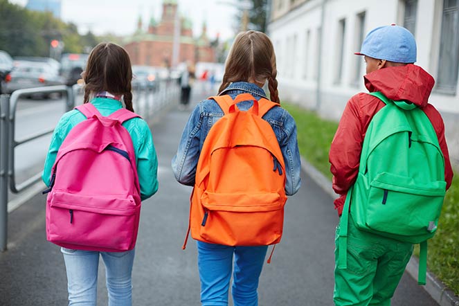 three students wearing backpacks