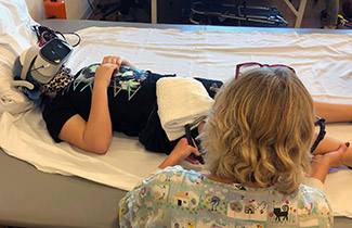 Karley usando gafas de realidad virtual durante la terapia