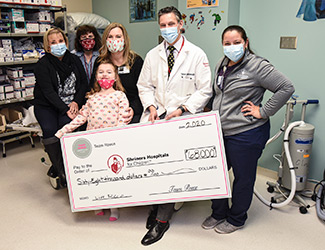 Reece with family and staff during check donation