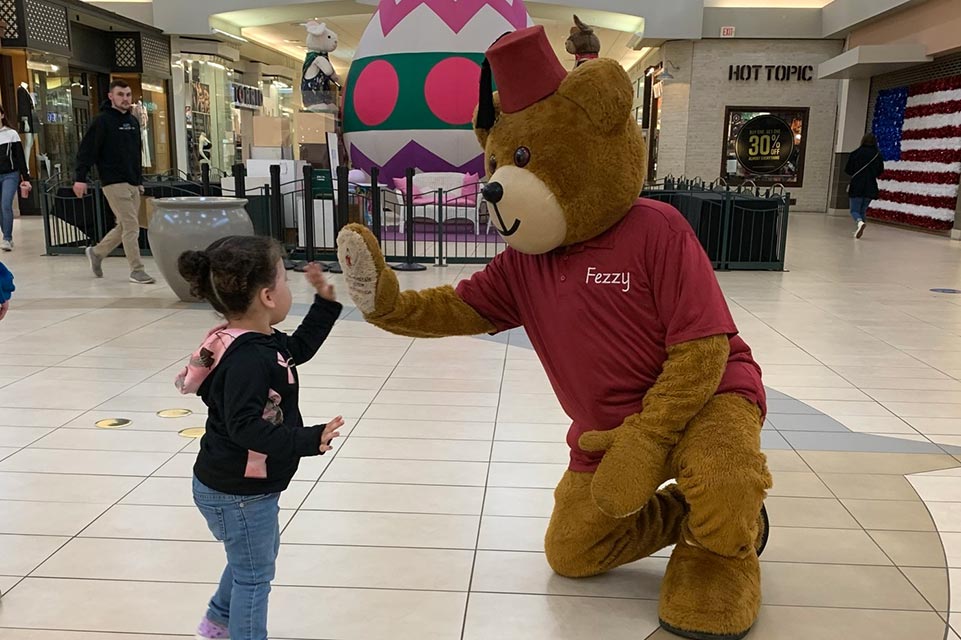 Fezzy bear high fiving patient