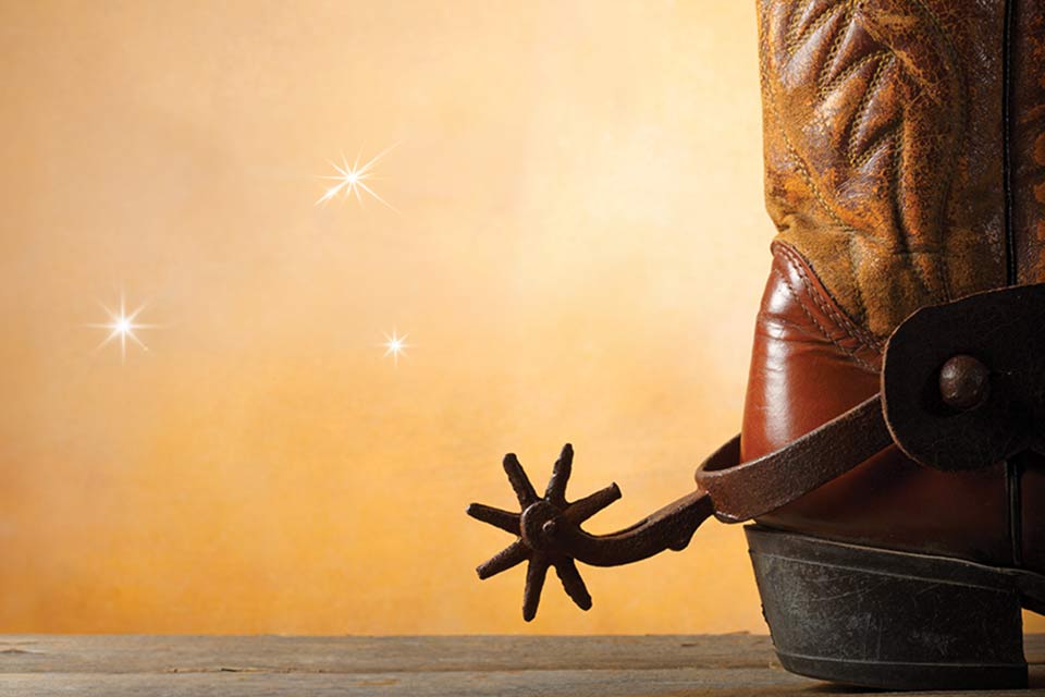 Cowboy boot on gold colored background