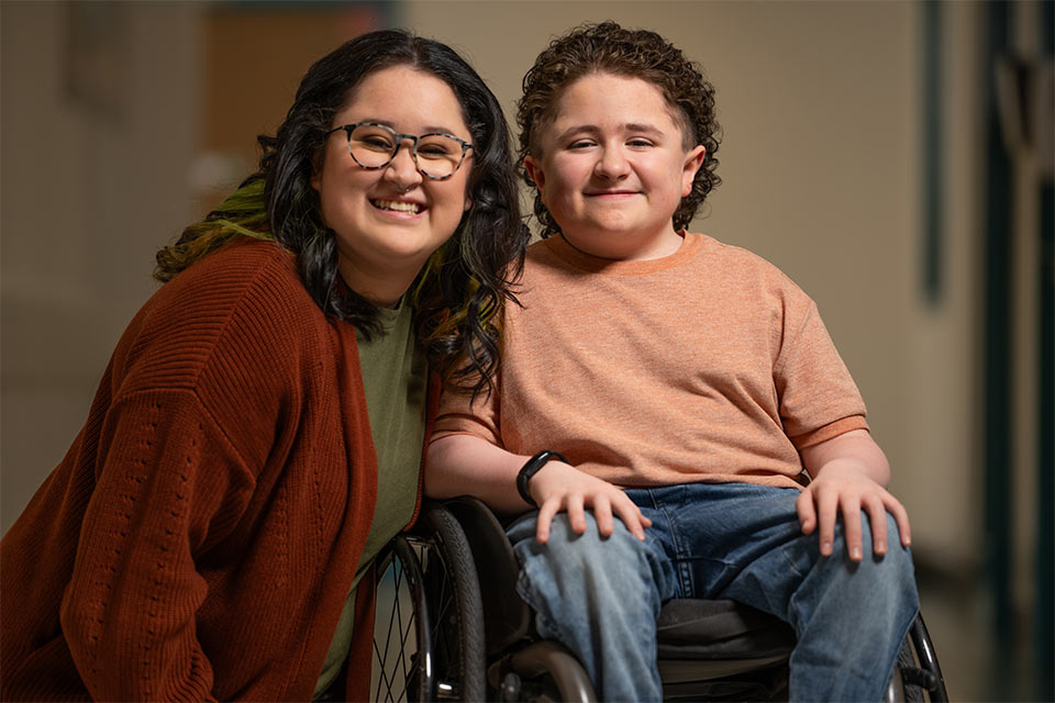 patient smiling in wheelchair next to sister