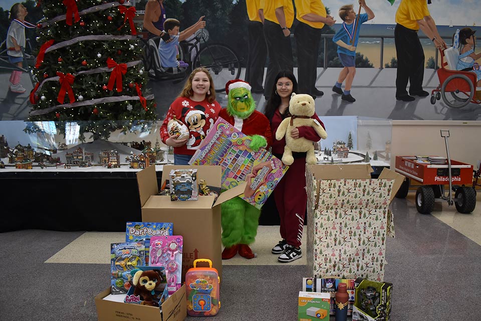 Christmas toys and decorations, two staff members, Grinch