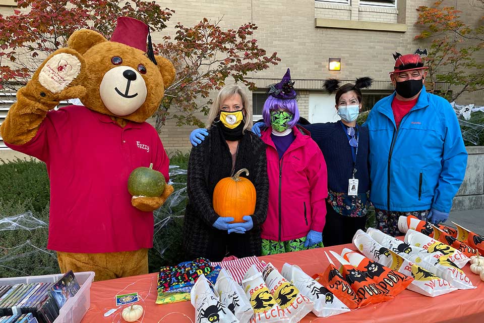 Hospital staff in costumes with Fezzy bear
