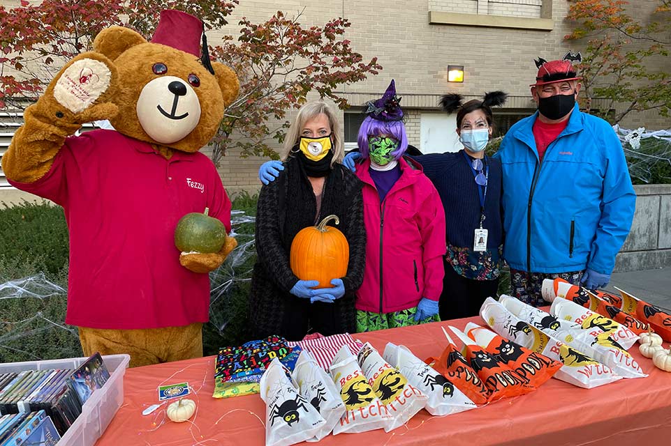 Fezzy bear with staff members and Halloween supplies