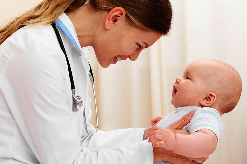 Proveedora femenina sosteniendo a un bebé en la clínica