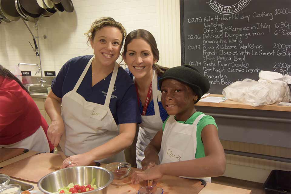 Lori with a female co-worker and female patient making salad at an outing