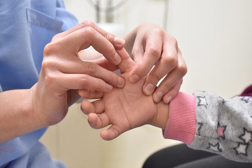 personal que trata la mano de un paciente