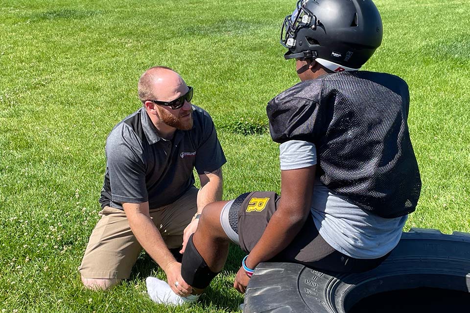 athletic trainer working with athlete