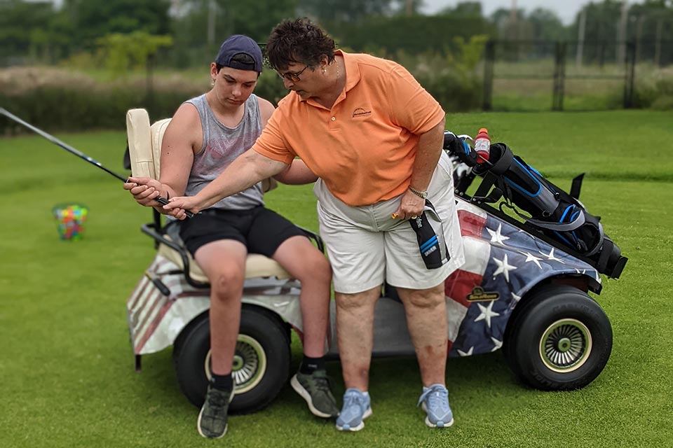 Terapeuta y paciente durante una lección de golf en el campo