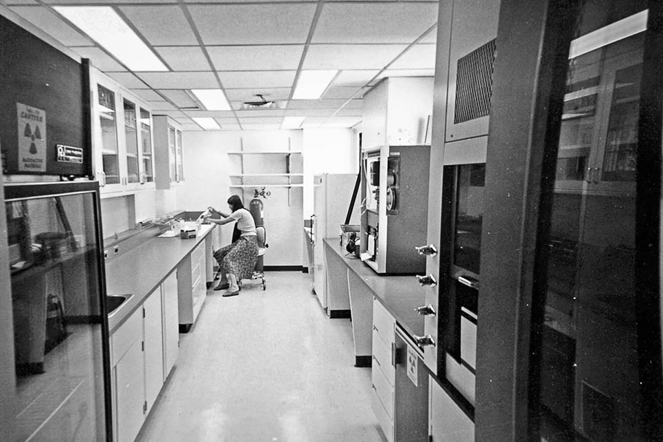 Imagen histórica de una mujer trabajando en el laboratorio.