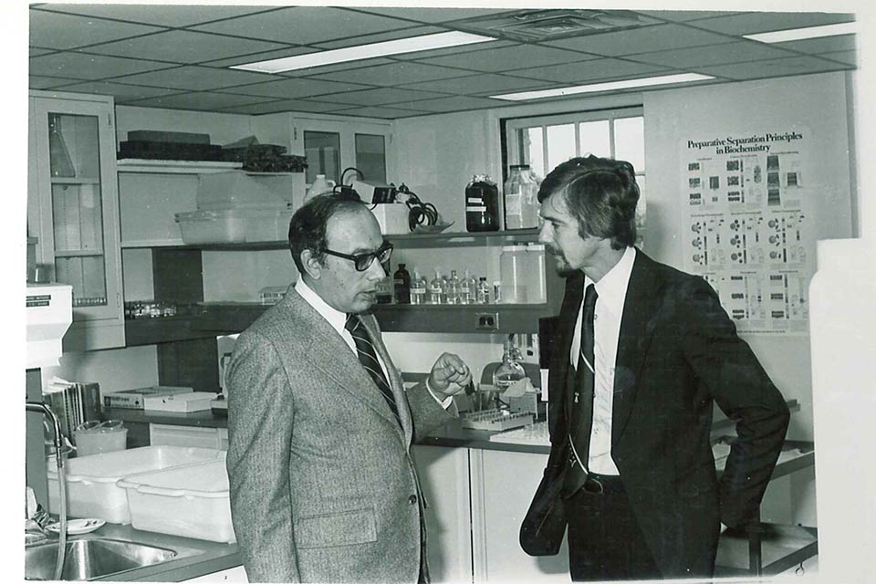 Historic image of two men in discussion in lab
