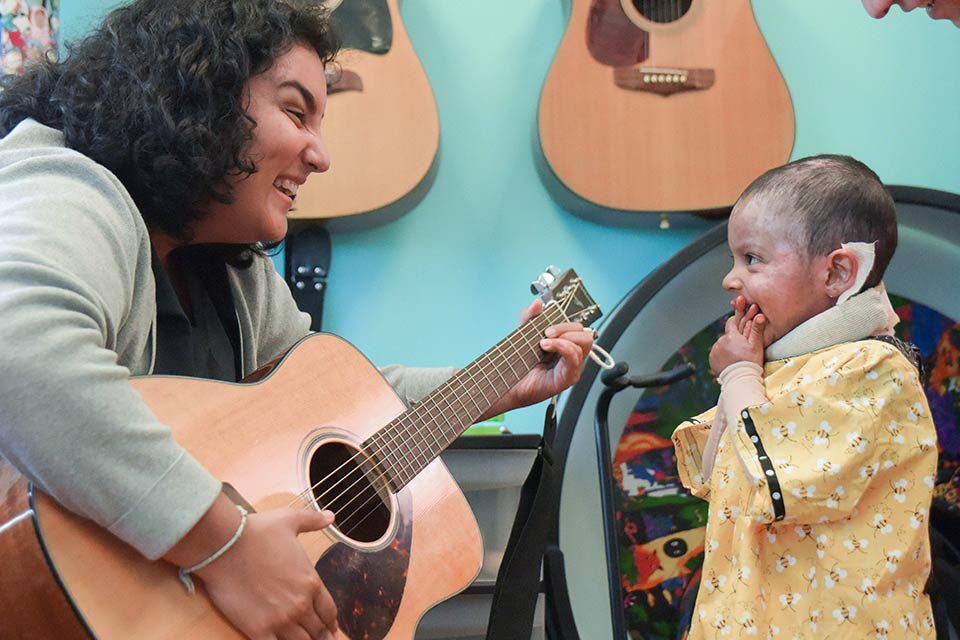 Ángela tocando la guitarra para un paciente