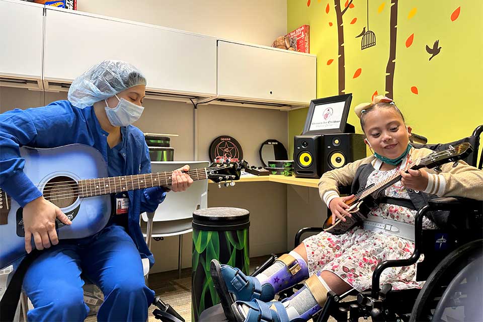Un patient avec une infirmière jouant de la guitare dans une salle de musicothérapie