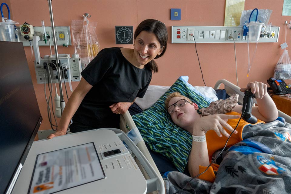 Maya Evans, M.D., and an IRU patient playing videogames