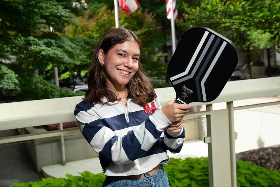 young woman holds pickleball racquet