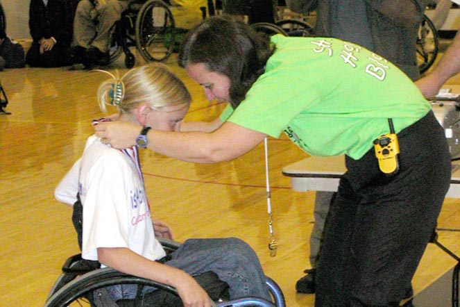 young Susannah receiving a medal at adaptive sports clinic