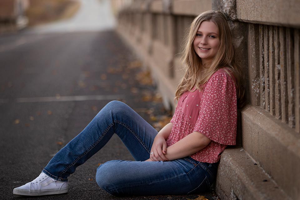 Malorie sitting on the ground with her back against a bridge wall