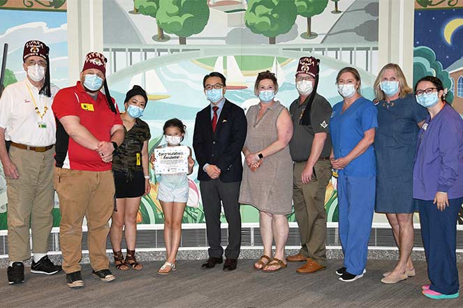 Annabelle with a group of doctors, nurses and Shriners on the day she rang the bell