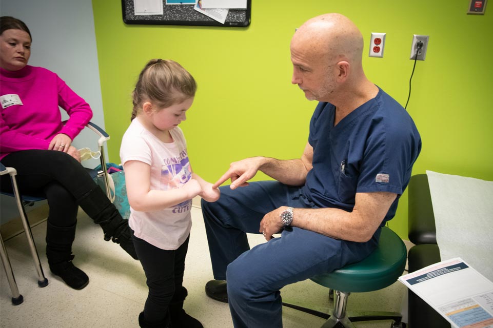 paciente con médico mirándole la mano