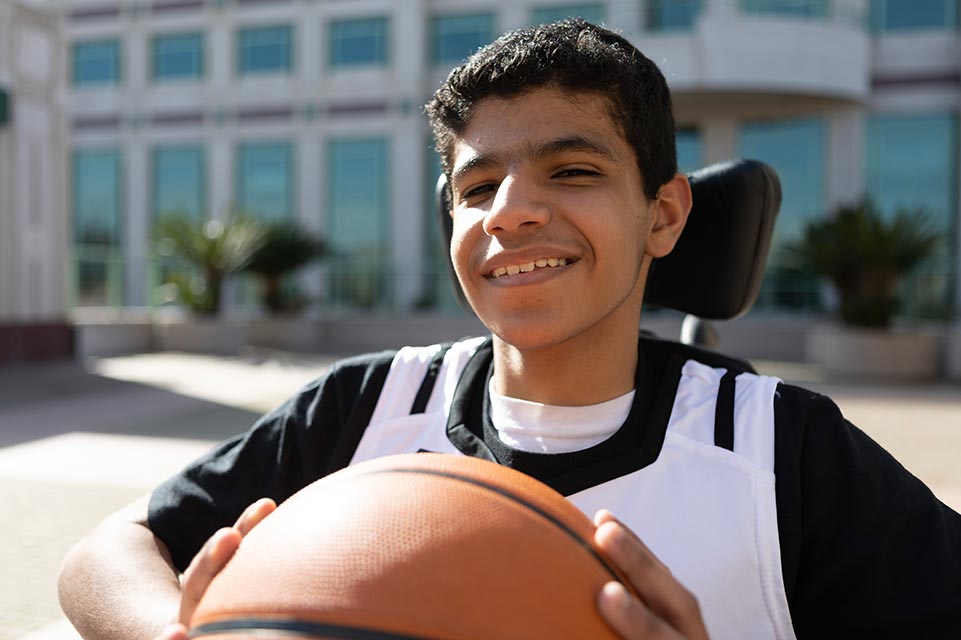 Mohammed sonriendo con balón de baloncesto