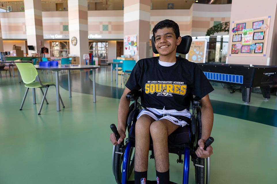 Mohammed souriant dans son fauteuil roulant
