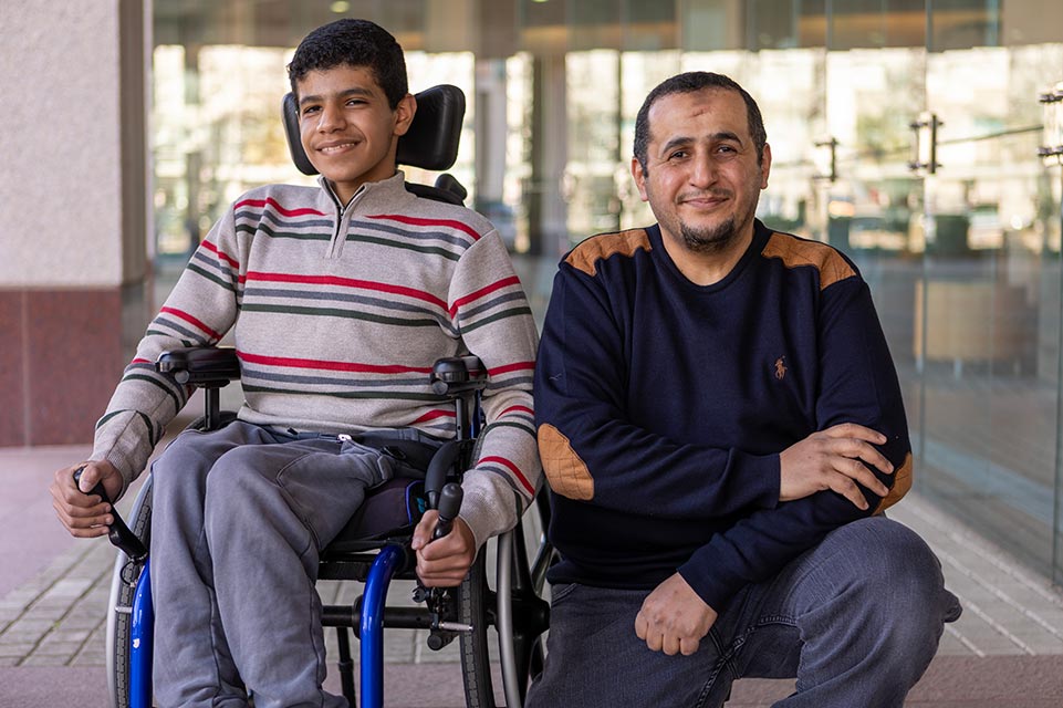 Mohammed en fauteuil roulant à côté d’un membre de sa famille
