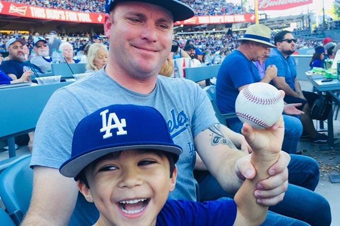 Weston con su papá en un partido de béisbol