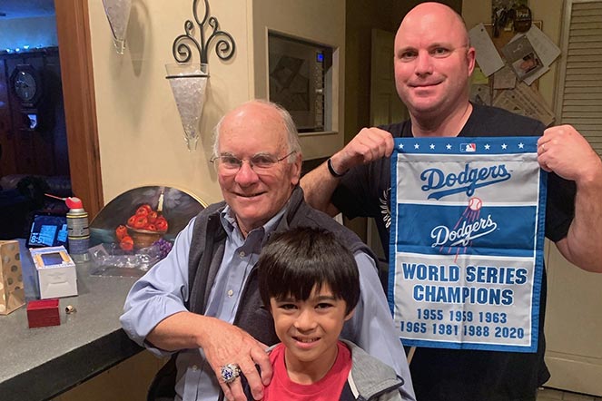 Tío Bob, Weston y su padre, el padre sosteniendo el banderín de los Dodgers, con el texto “Campeones de la Serie Mundial de 1955, 1959, 1963, 1965, 1981, 1988, 2020”