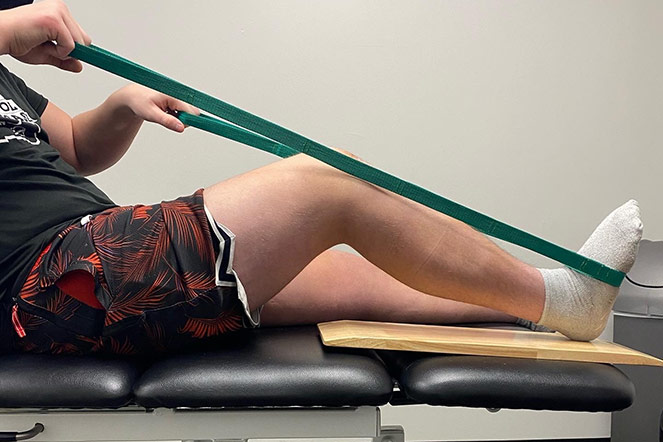Hunter faisant une thérapie des jambes avec une bande élastique